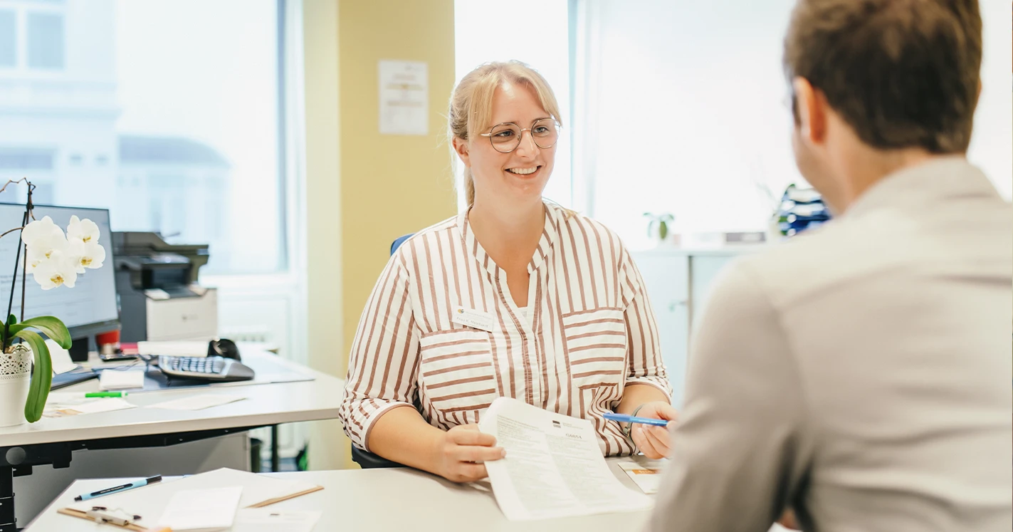 Eine Dame bei einem Gespräch mit einem Rehabilitanden.