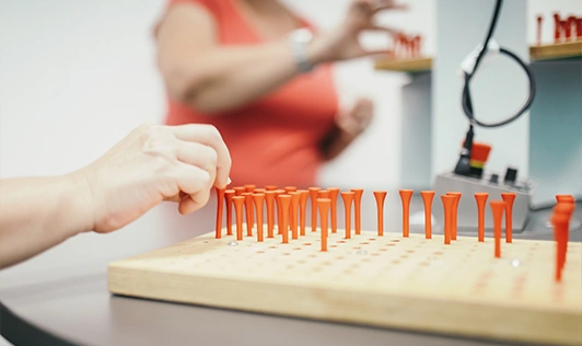 Darstellung einer Übung aus der Ergotherapie, bei der die Greiffähigkeit geübt wird.